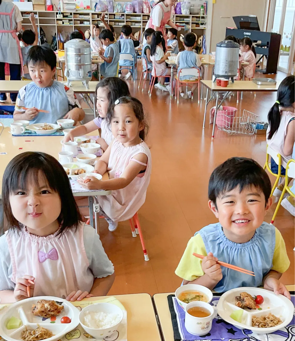 子どもたちが笑顔で給食を食べている様子